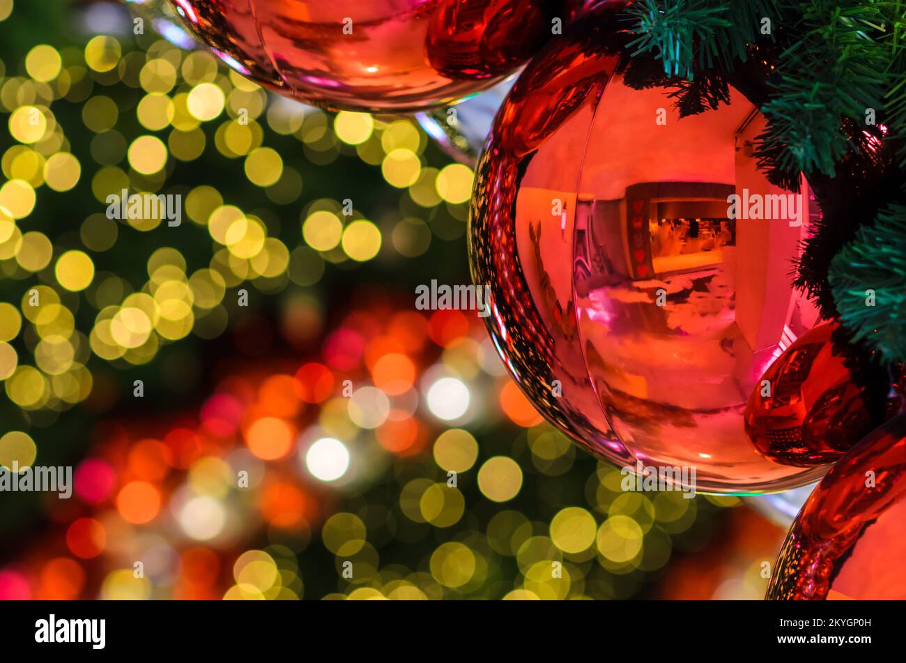 Bauble rosso e altro ornamento appeso all'albero di Natale con sfondo chiaro bokeh. Foto Stock