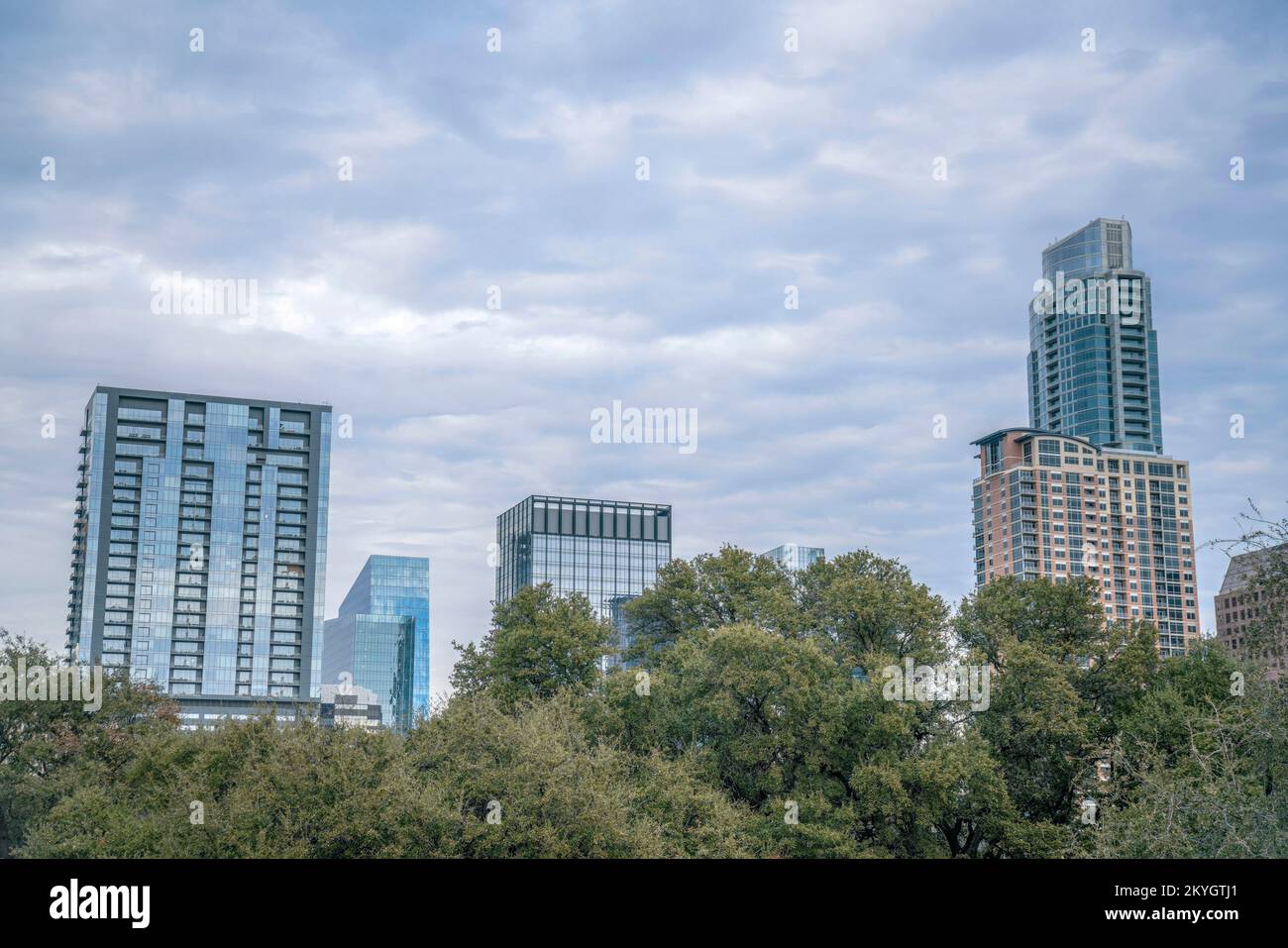 Residenziali e imprese ad alto rischio contro il cielo nuvoloso - Austin, Texas. Ci sono alberi sotto la vista della città dal Butler Metro Park. Foto Stock