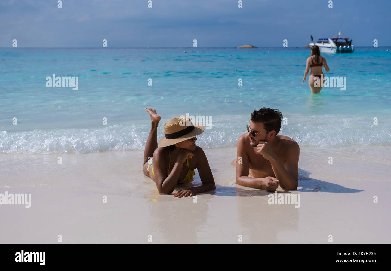 Uomini e donne che prendono il sole su una spiaggia bianca, Un paio di uomini e donne in un viaggio all'isola tropicale con spiaggia bianca Isole Similan Thailandia. Foto Stock