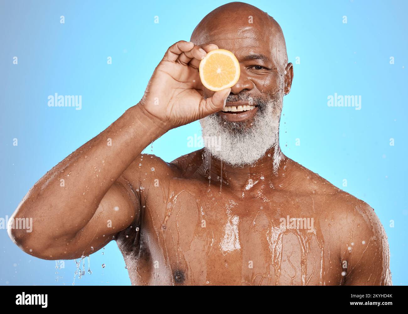 Uomo viso, frutta e acqua splash in cura della pelle governare, Nigeria salute benessere o vitamina C trattamento su sfondo blu studio. Ritratto, felice Foto Stock