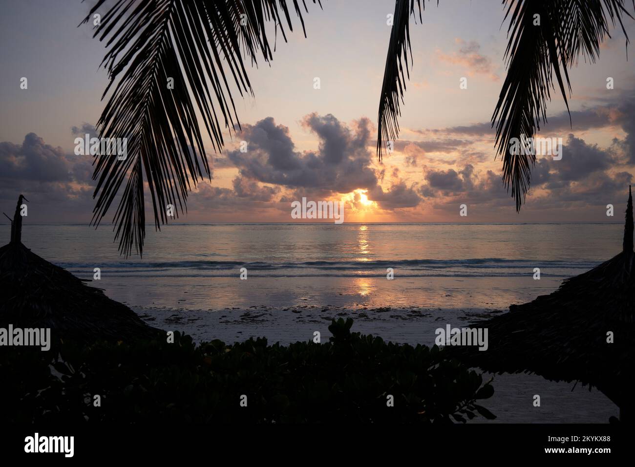 Il Sole d'Oro sorge e i raggi si infrangono attraverso la nuvola di fronte alla spiaggia di Matemwe in Tanzania Foto Stock