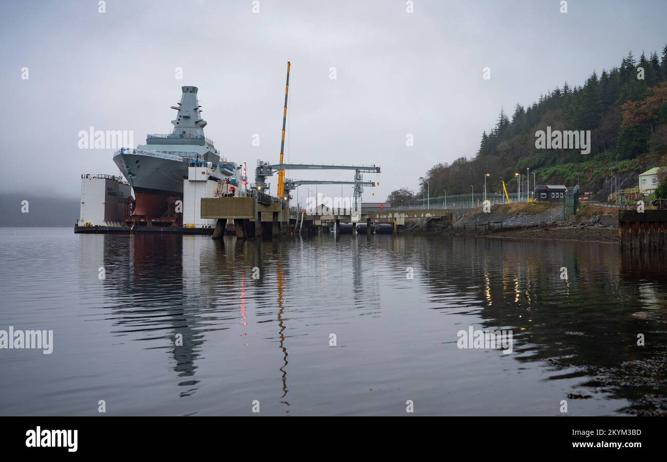 Glen Mallan, Scozia, Regno Unito. 1st dicembre 2022. Vista dell'HMS Glasgow a Glen Mallan sul Loch Long a Argyll e Bute. La nave da guerra sottomarina di tipo 26 della Royal Navy è stata trasportata ieri dal cantiere navale di BAE Systems Govan. Attualmente sta lentamente abbassandosi nel lago d'acqua profonda dalla chiatta di sostegno - che è stata allagata per affondare sotto la nave da guerra. HMS Glasgow tornerà quindi nel cantiere navale BAE di Scotstoun dove sarà completata. Iain Masterton/Alamy Live News Foto Stock