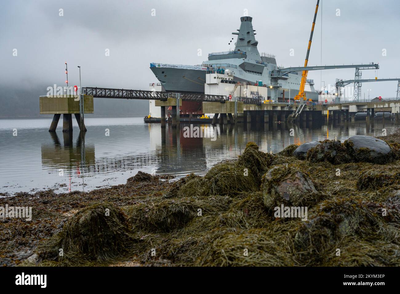 Glen Mallan, Scozia, Regno Unito. 1st dicembre 2022. Vista dell'HMS Glasgow a Glen Mallan sul Loch Long a Argyll e Bute. La nave da guerra sottomarina di tipo 26 della Royal Navy è stata trasportata ieri dal cantiere navale di BAE Systems Govan. Attualmente sta lentamente abbassandosi nel lago d'acqua profonda dalla chiatta di sostegno - che è stata allagata per affondare sotto la nave da guerra. HMS Glasgow tornerà quindi nel cantiere navale BAE di Scotstoun dove sarà completata. Iain Masterton/Alamy Live News Foto Stock