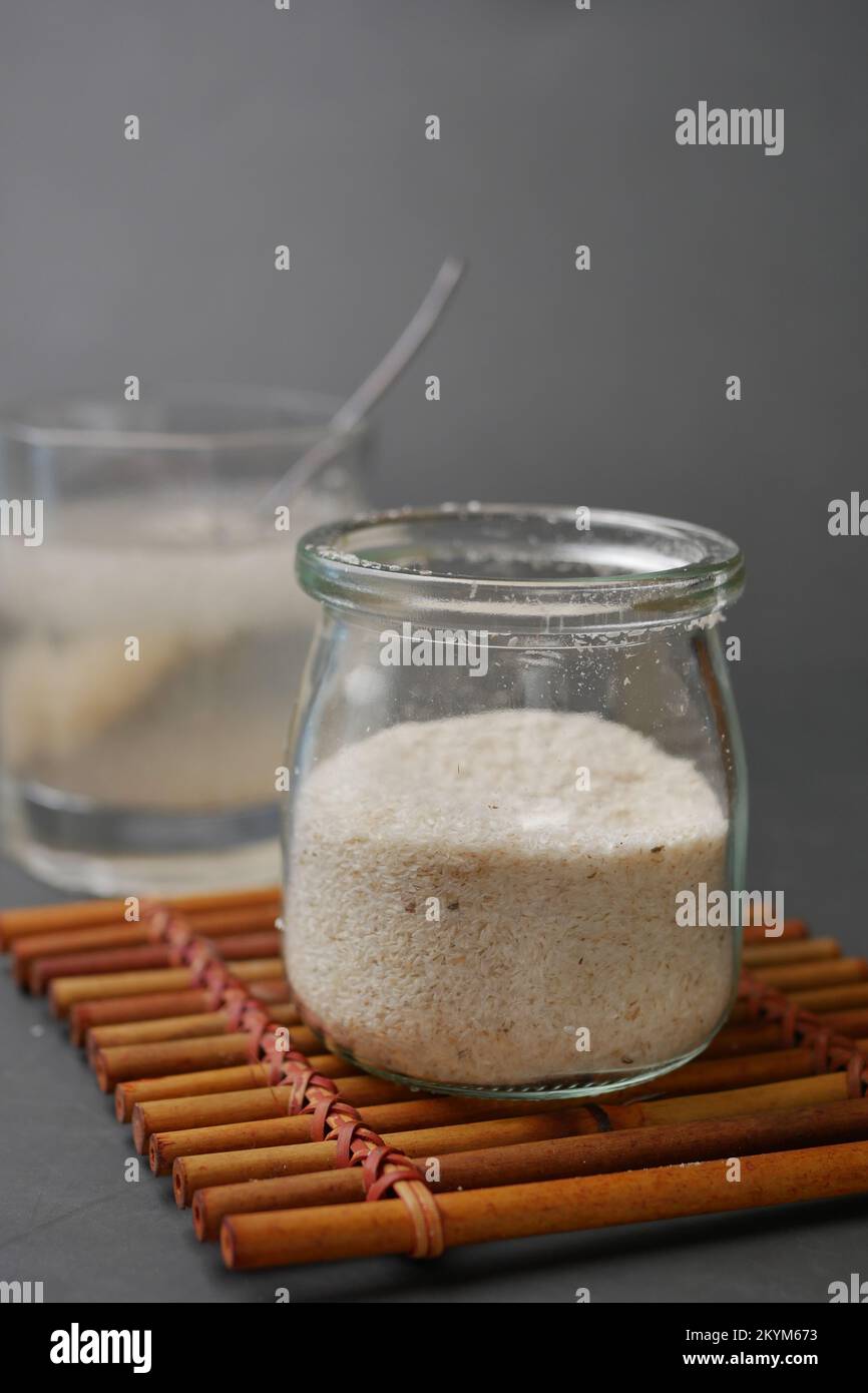 Il cucchiaio di legno con semi di psillio su sfondo scuro Foto Stock