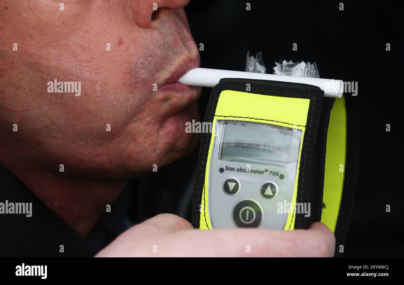 Un conducente soffia in un respiratore al lancio della polizia invernale 2022/23 anti-drink / droga guida operazione su Sydenham Road a Belfast. Data immagine: Giovedì 1 dicembre 2022. Foto Stock
