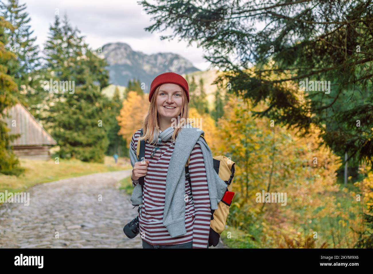 Escursione nella foresta donna turista con zaino giallo in piedi sul sentiero nel bosco. Trekking persone attive lifestyle indossare zaino esercizio all'aperto. Foto Stock