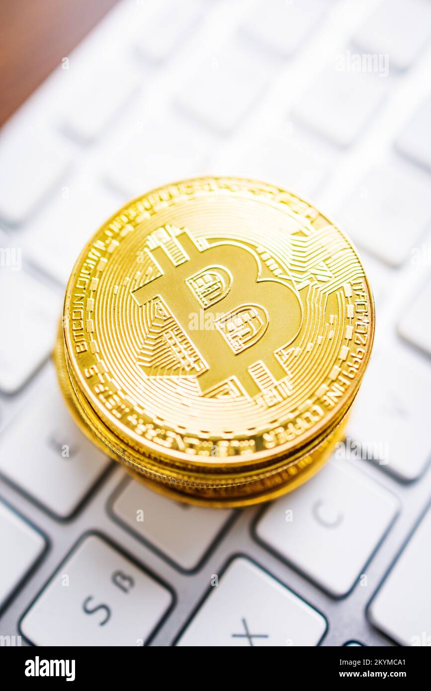 Criptovaluta. Denaro virtuale Bitcoin. Monete d'oro appoggiate sulla tastiera del computer. Foto Stock