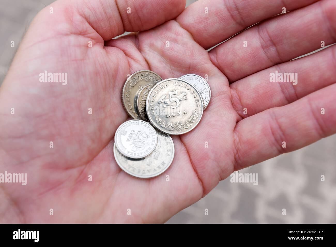 Lovran, Croazia - 8 settembre 2022: Uomo che tiene in mano le monete croate di Kuna e Lipa. Kuna è la valuta utilizzata in Croazia dal 1194 e sarà in uso Foto Stock