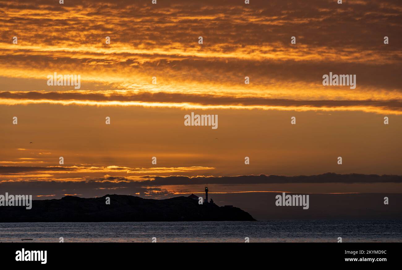 Alba sullo stretto di Juan de Fuca e il Faro delle Trial Islands, visto da Ross Bay a Victoria, British Columbia, Canada. Foto Stock