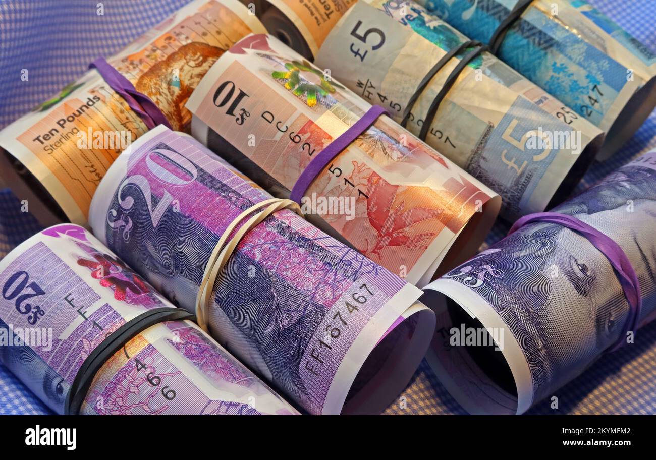 Rotoli di banconote scozzesi, tenuti insieme da bande elastiche, nero solo denaro economia Foto Stock
