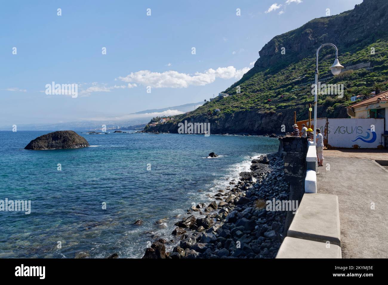 Gente del posto, compreso un pescatore, sul lungomare di Las Aguas, San Juan de la Rambla, Tenerife, Isole Canarie, Spagna, ottobre 2022. Foto Stock