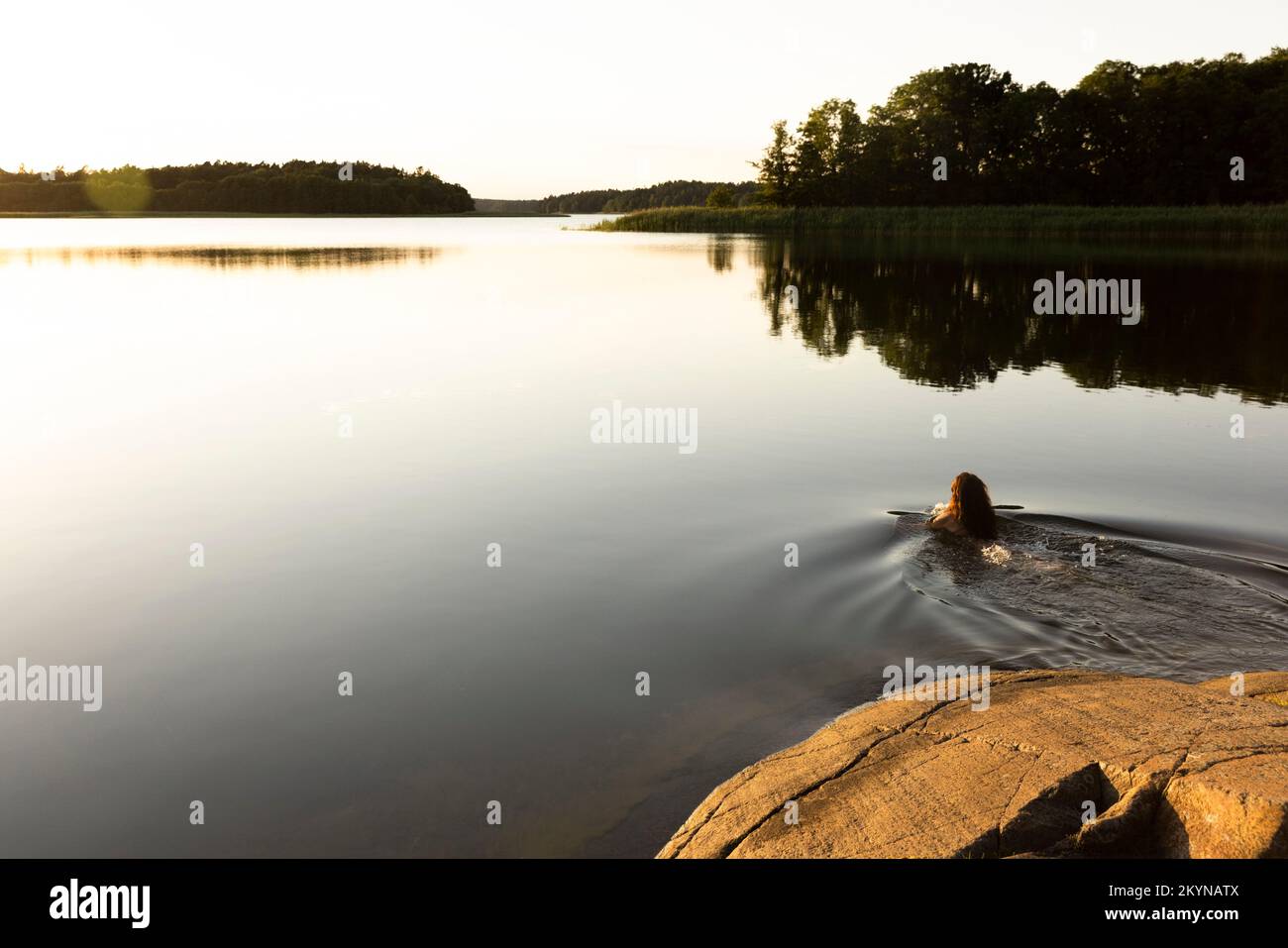 Donna che nuota in lago durante le vacanze Foto Stock