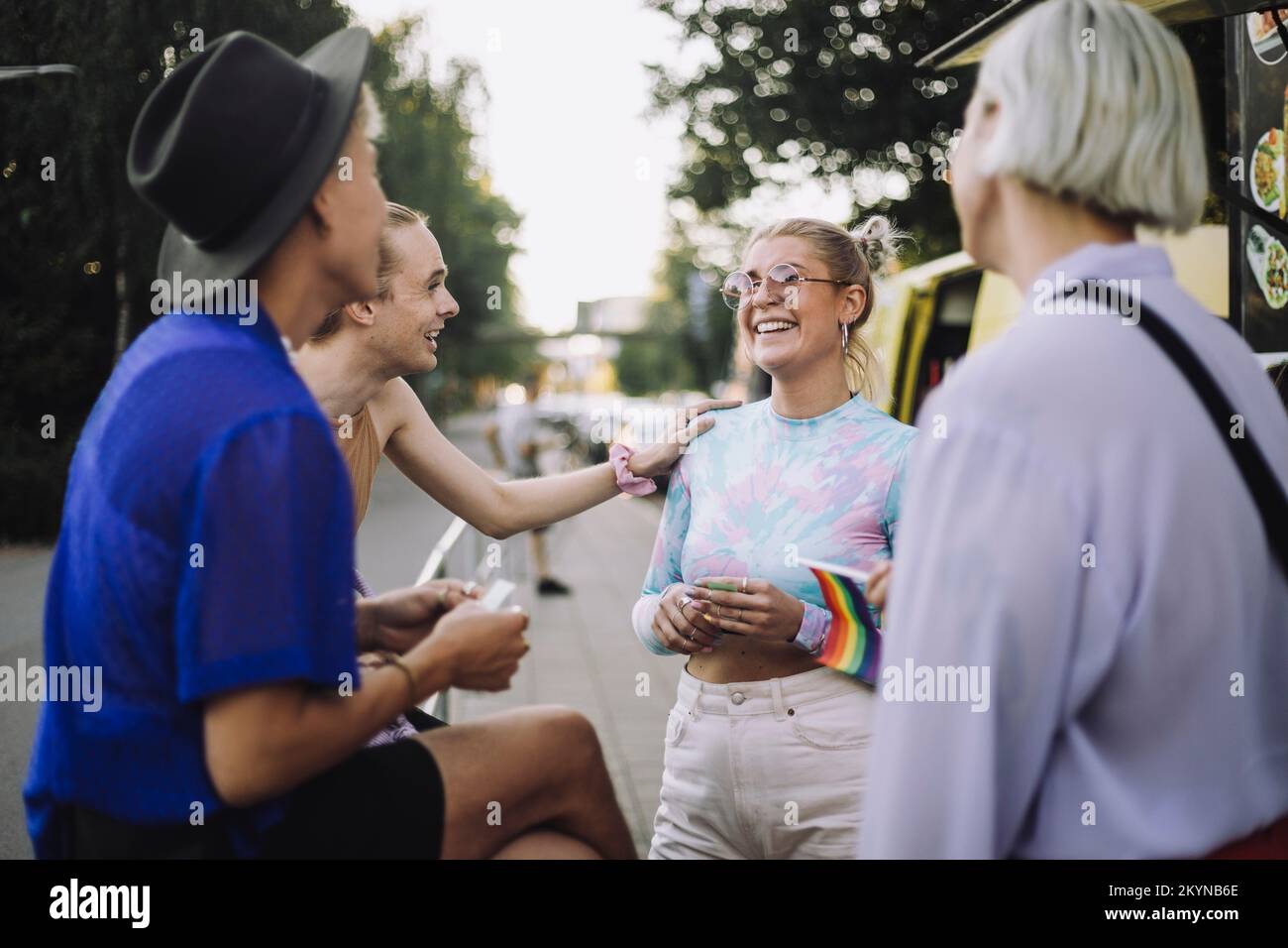 Felice non-binary persona che parla con la donna da amici Foto Stock