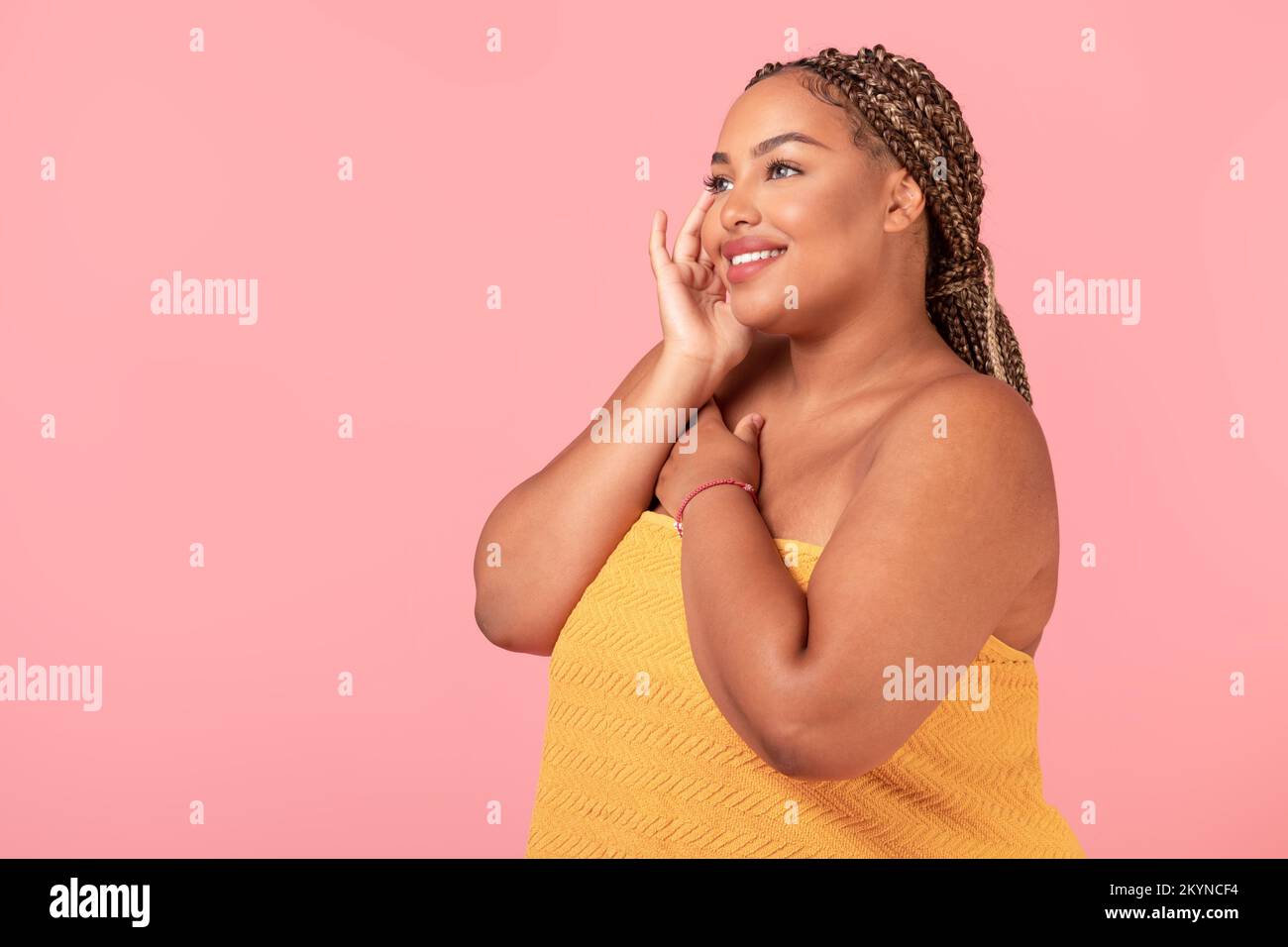 Bella donna nera oversize in piedi avvolto in asciugamano dopo il bagno, godendo la sua bellezza naturale, spazio libero Foto Stock