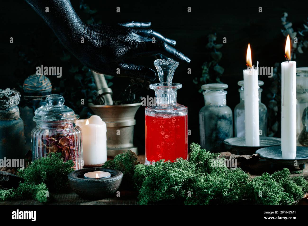 strega nera mano apertura pozione magica, erbe ingredienti candele e attrezzatura magica Foto Stock