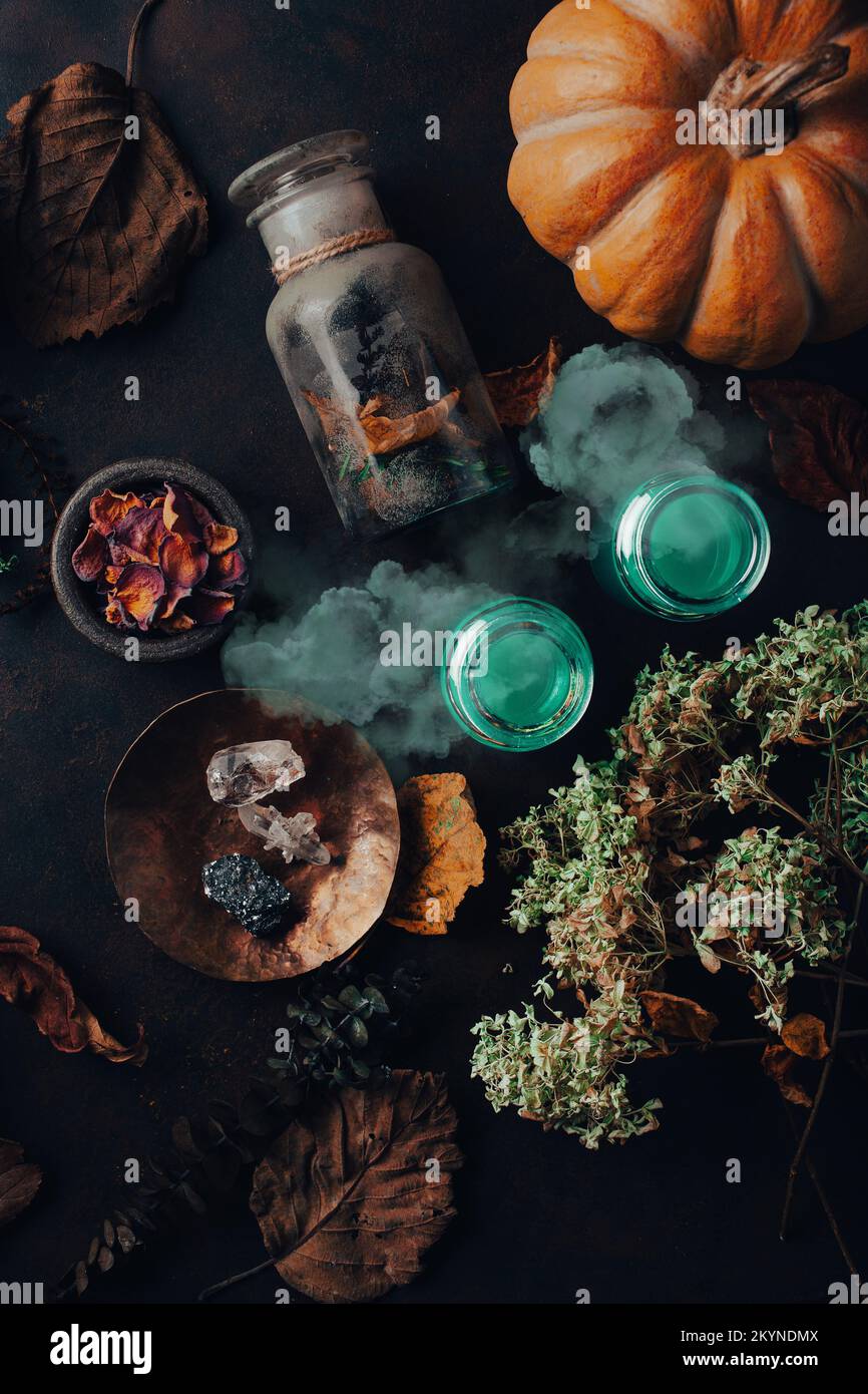 Witchcraft ancora vita concetto con pozione fumo, erbe ingredienti candele e attrezzature magiche Foto Stock
