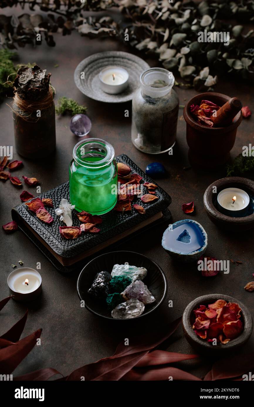 Concetto di vita still witchcraft con pozione, libro incantesimo, erbe ingredienti candele e attrezzature magiche Foto Stock