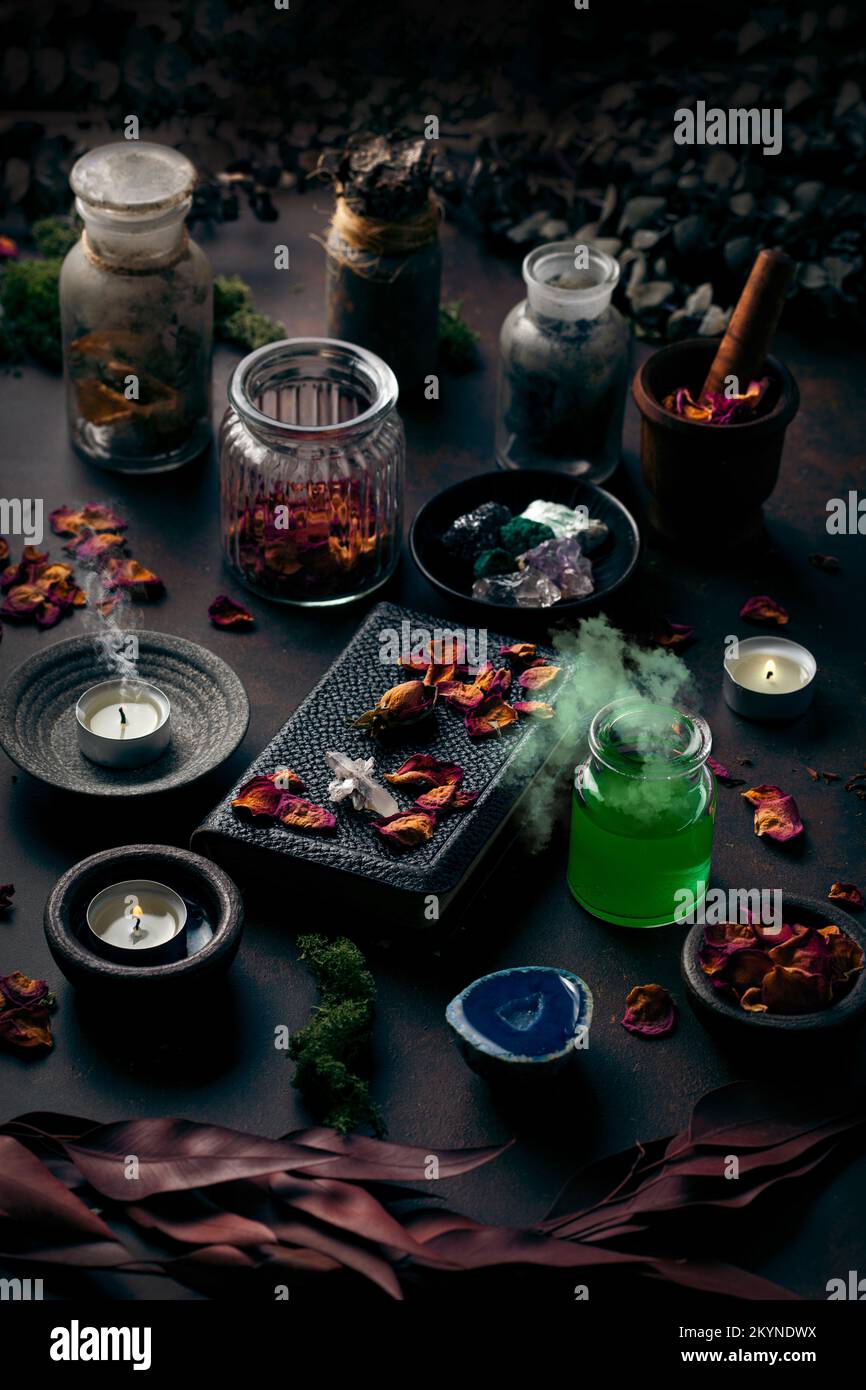 Concetto di vita still witchcraft con pozione fumante, libro incantesimo, candele ingredienti erbe e attrezzatura magica Foto Stock