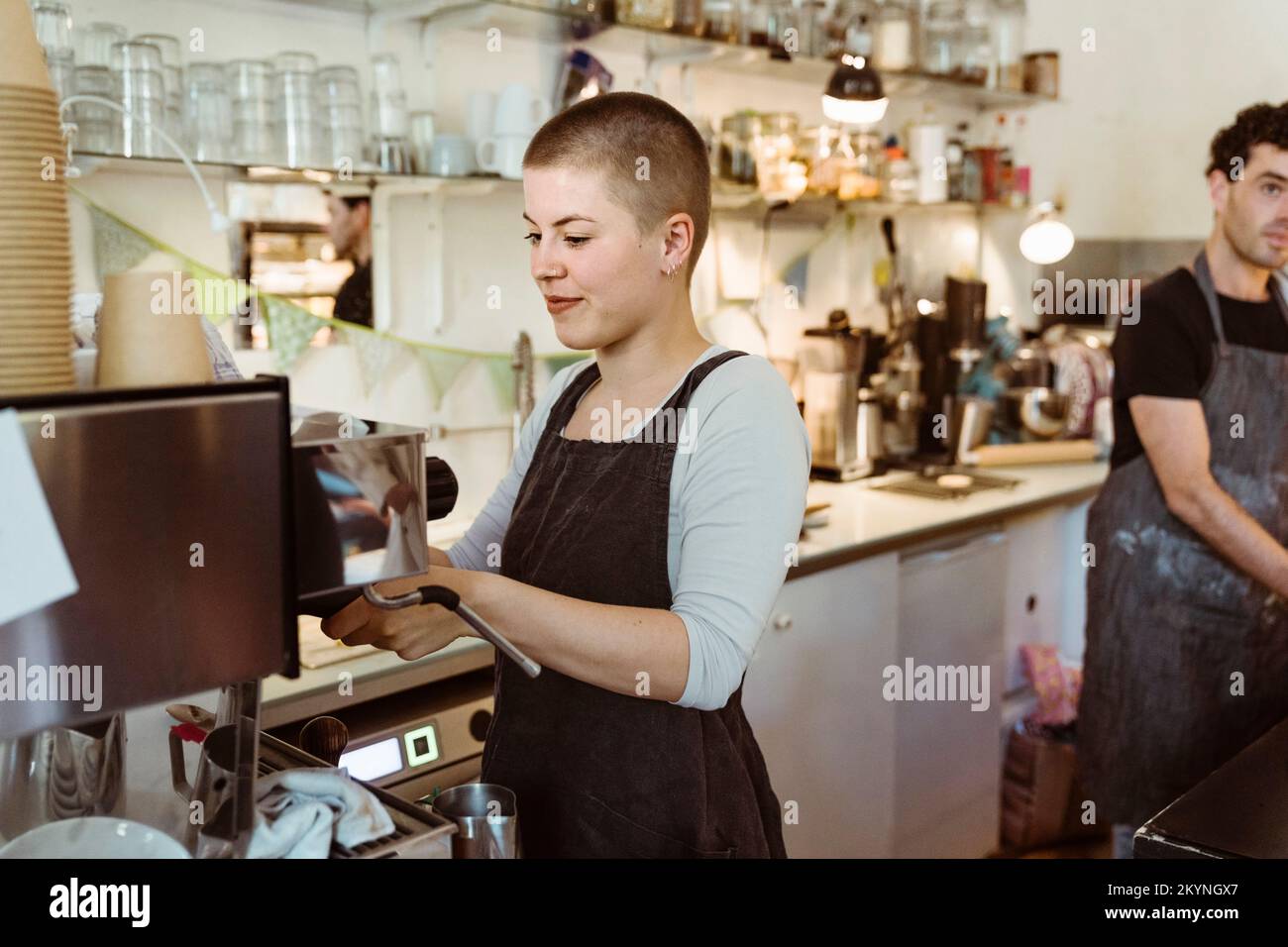 Giovane barista che prepara il caffè al bar Foto Stock