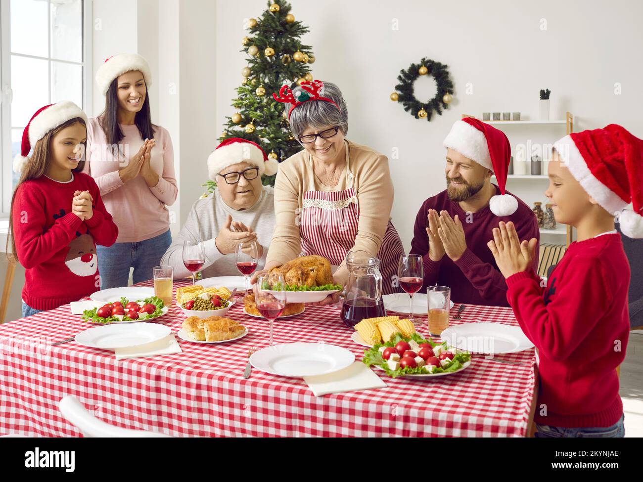 La famiglia felice ha cena con la famiglia, che serve il piatto principale caldo. Foto Stock