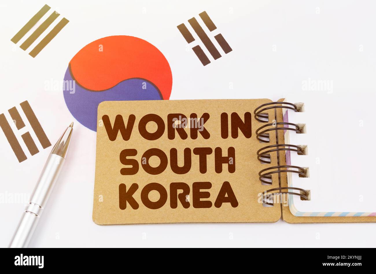 Concetto di economia nazionale. Sulla bandiera della Corea del Sud si trova un quaderno con l'iscrizione - opera in Corea del Sud Foto Stock