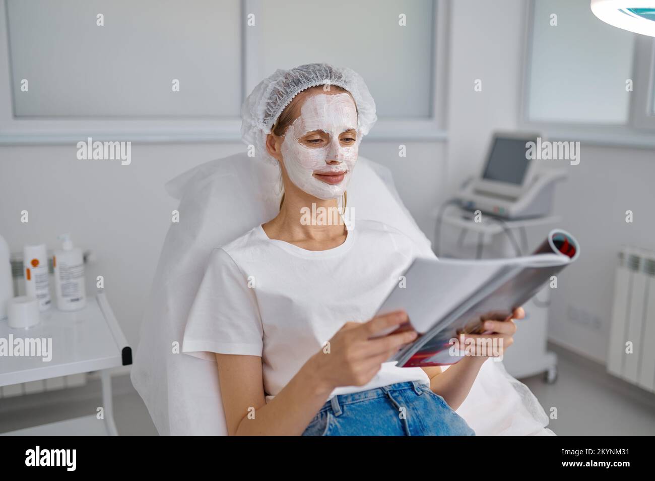 Cliente donna in maschera di argilla rilassante presso l'ufficio cosmologia Foto Stock