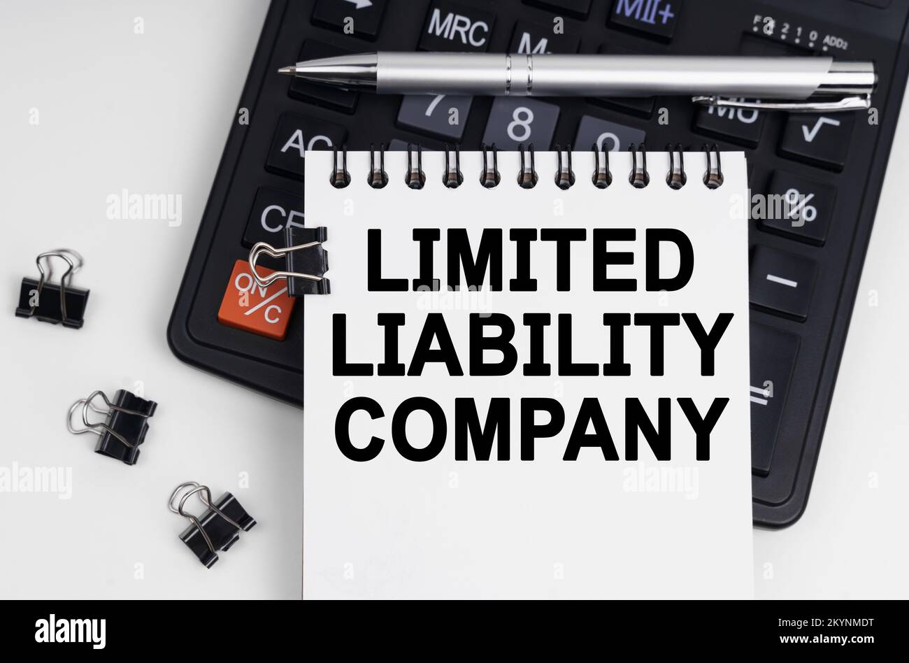 Concetto economico e commerciale. Sulla tabella sono riportati una calcolatrice, una penna e un notebook con l'iscrizione - SOCIETÀ A RESPONSABILITÀ LIMITATA Foto Stock