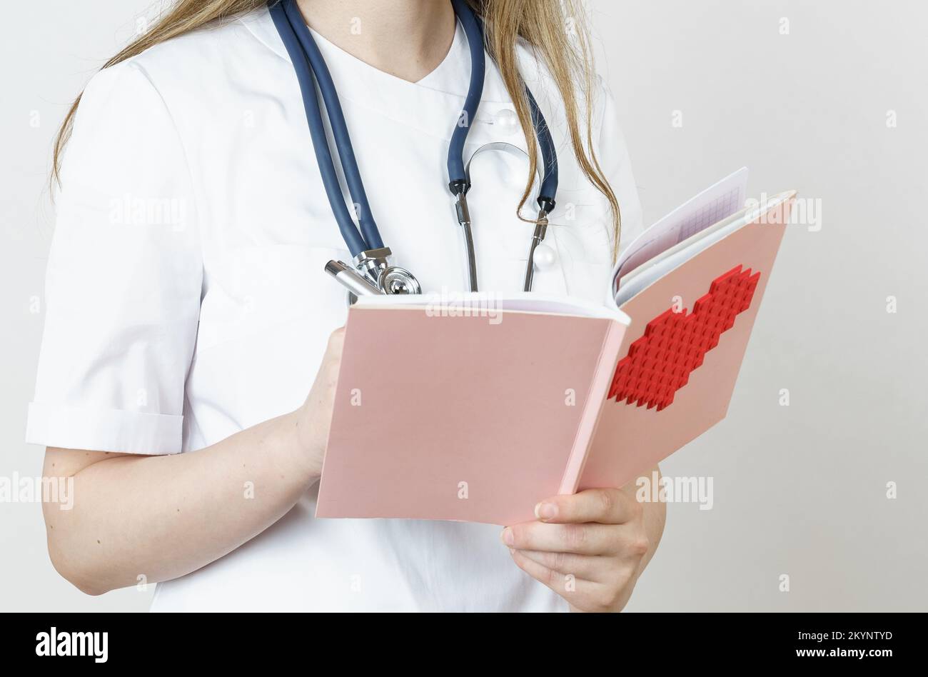 Medicina e concetto di salute. Una giovane dottoressa scrive in un taccuino. Isolato su bianco Foto Stock