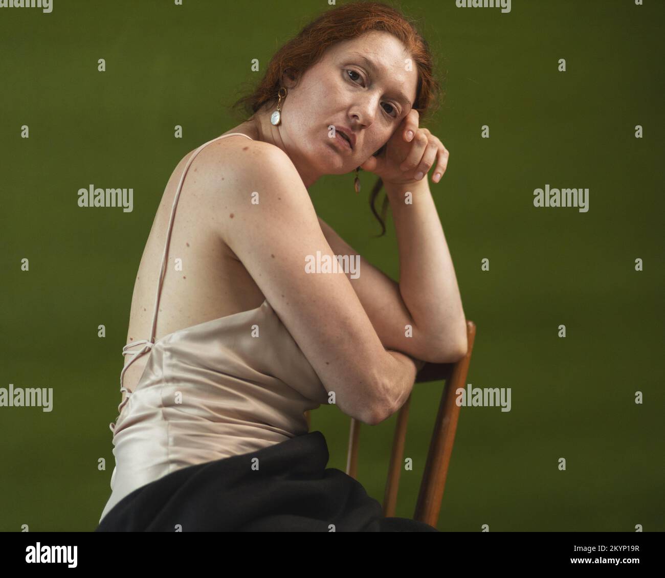 Ritratto di una giovane donna con capelli raccolti su sfondo verde Foto Stock