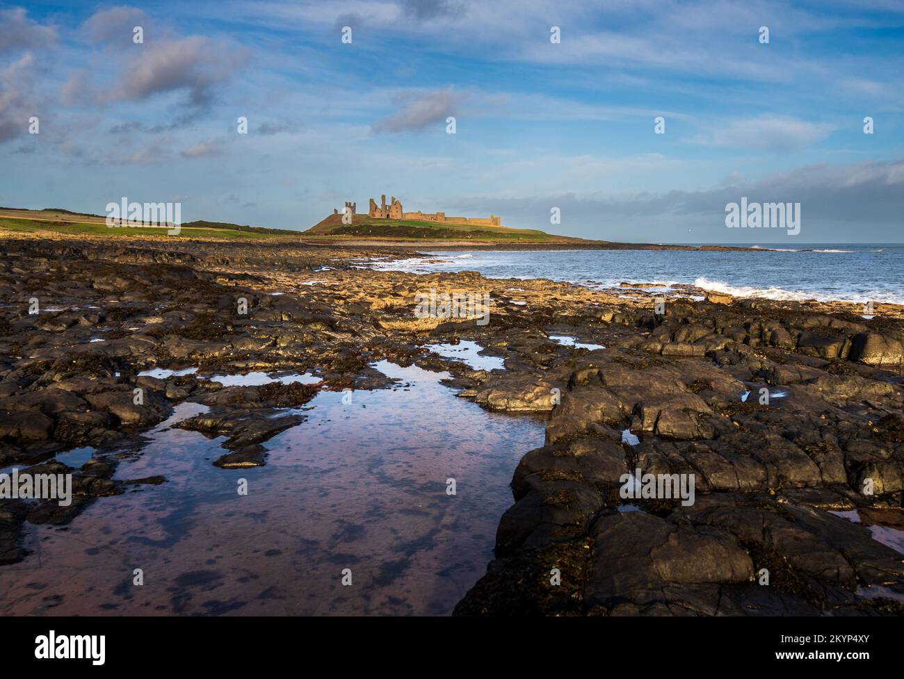 Dunstanburgh Castle vicino a Croster sulla costa del Northumberland, Inghilterra, Regno Unito Foto Stock