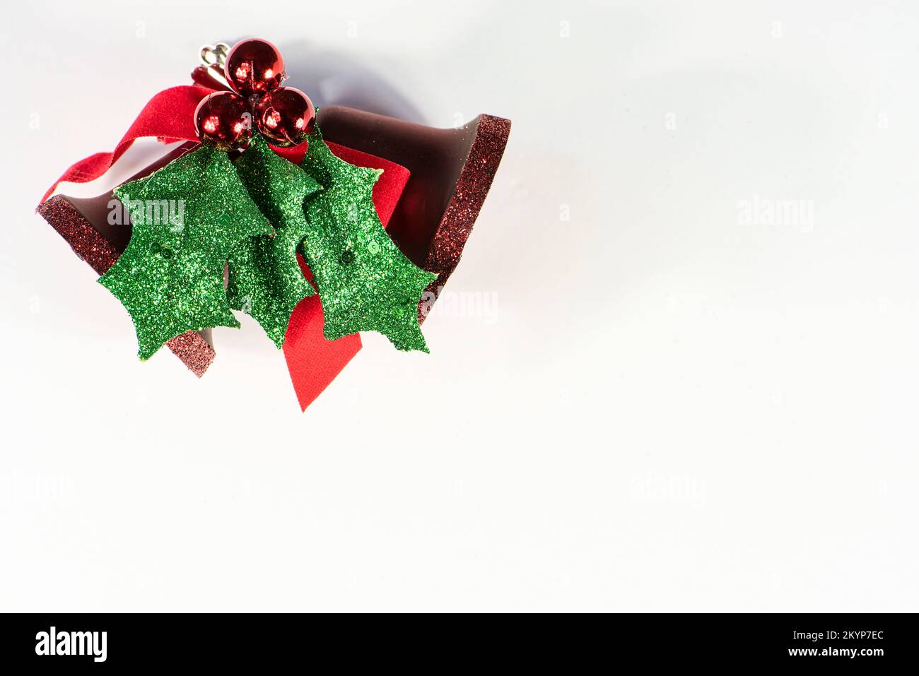 Allegro sfondo del biglietto di auguri di Natale, sfondo bianco, stanza per il testo, campana rossa e ornamento sempreverde Foto Stock