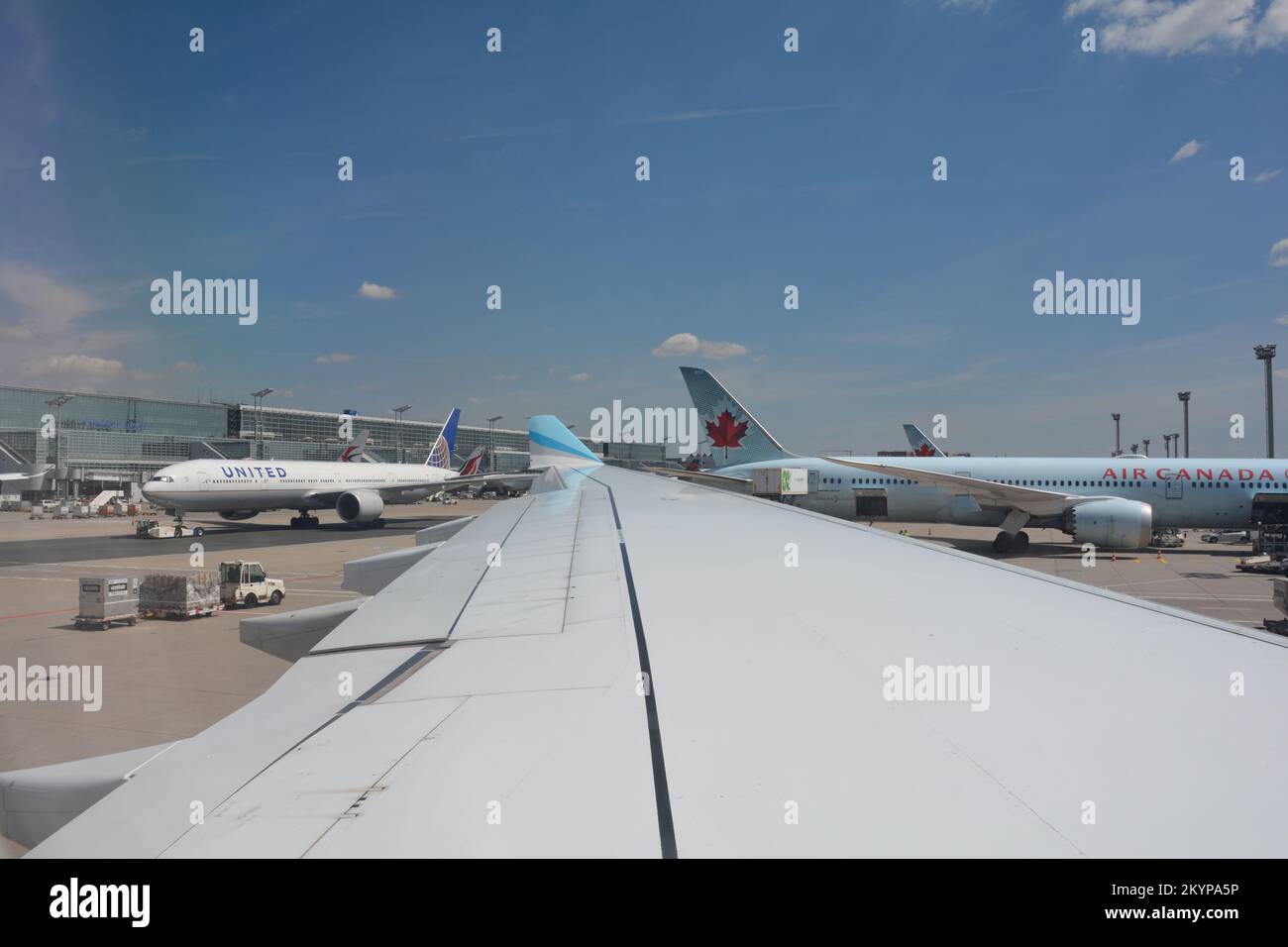 Aeroporto di Francoforte Germania 02 agosto 2022 - Vista dalla finestra dell'aeromobile su un'ala e una vista del terminal, una macchina unita che viene trainata a Th Foto Stock