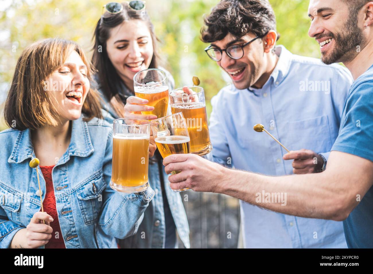 Gruppo di amici che bevono birra al bar della birreria all'aperto - felici amici genuini che si divertono insieme dopo il lavoro Foto Stock