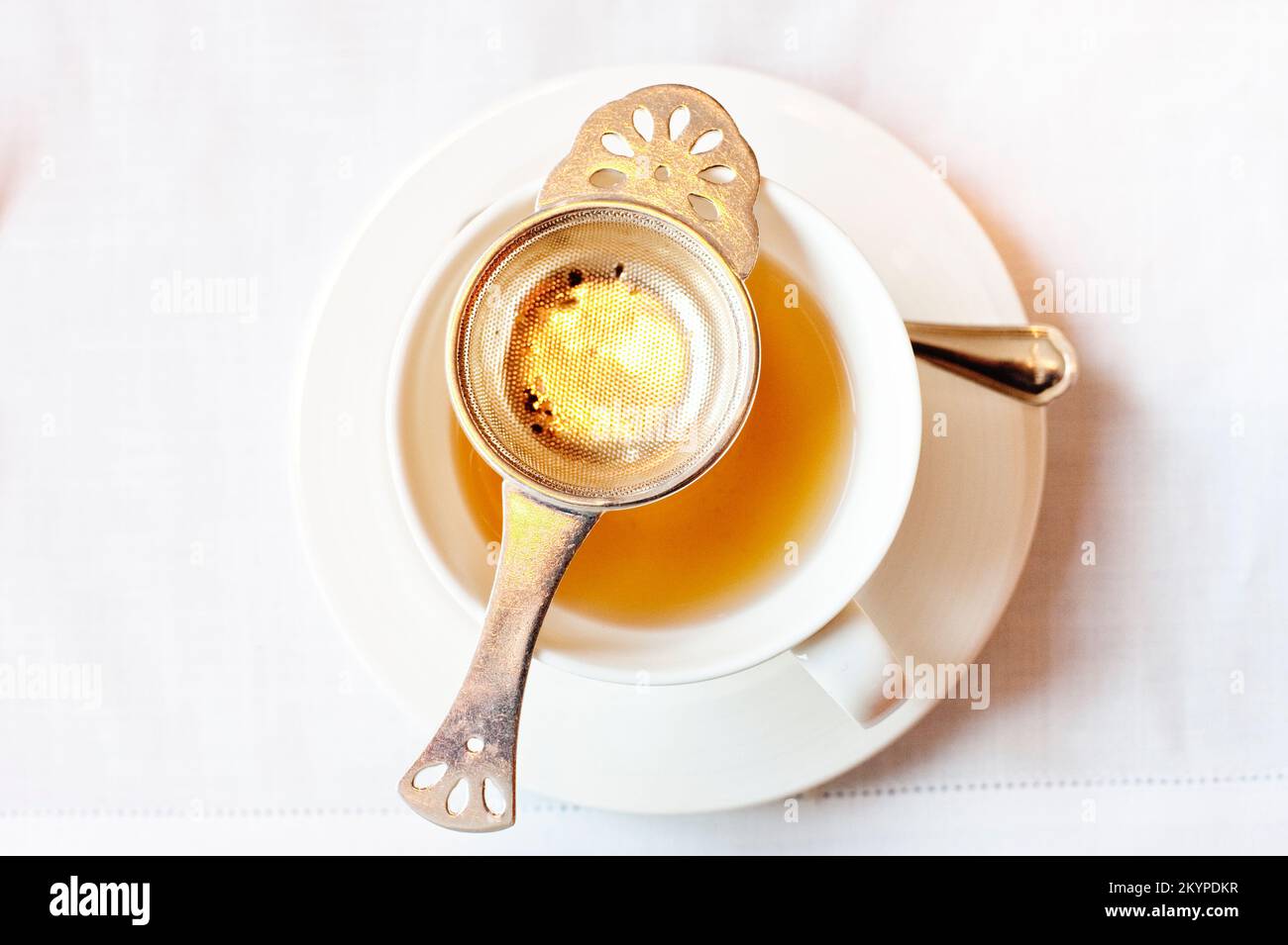 Una tazza di tè Oolong appena teso servito su una tovaglia di lino bianco con un filtro d'argento, il Mandarin Oriental's Clipper Lounge, Hong Kong. Foto Stock