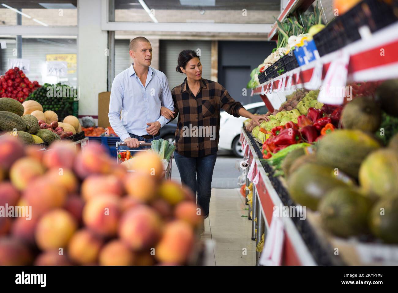 Coppia di famiglia in cerca di frutta e verdura in fruttivendolo Foto Stock
