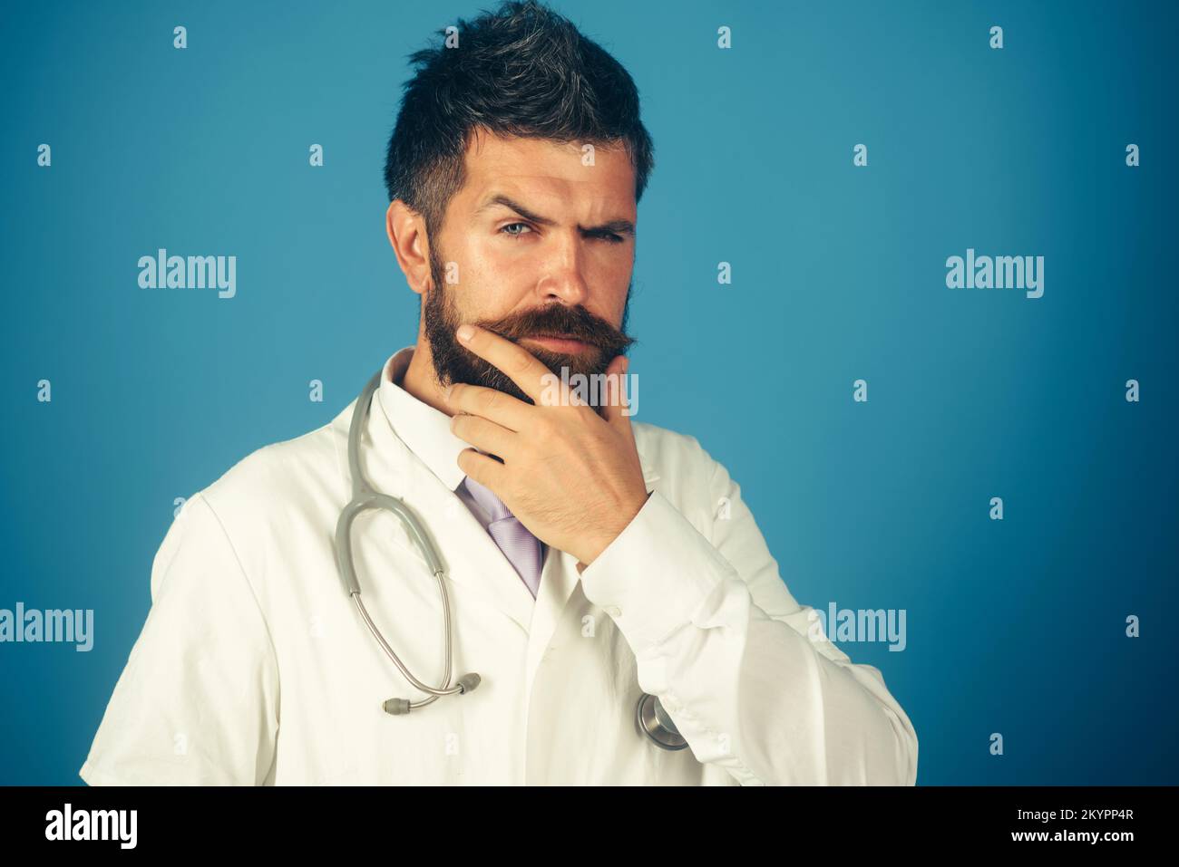 Medico serio sicuro con stetoscopio. Medico bearded in uniforme bianca. Spazio di copia. Foto Stock