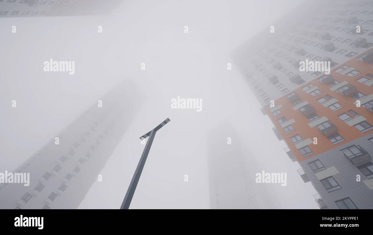 Alti edifici residenziali in nebbia. Azione. Vista dal basso di alti edifici protetti da una fitta nebbia. Tempo nuvoloso con nebbia avvolge alti piani b Foto Stock