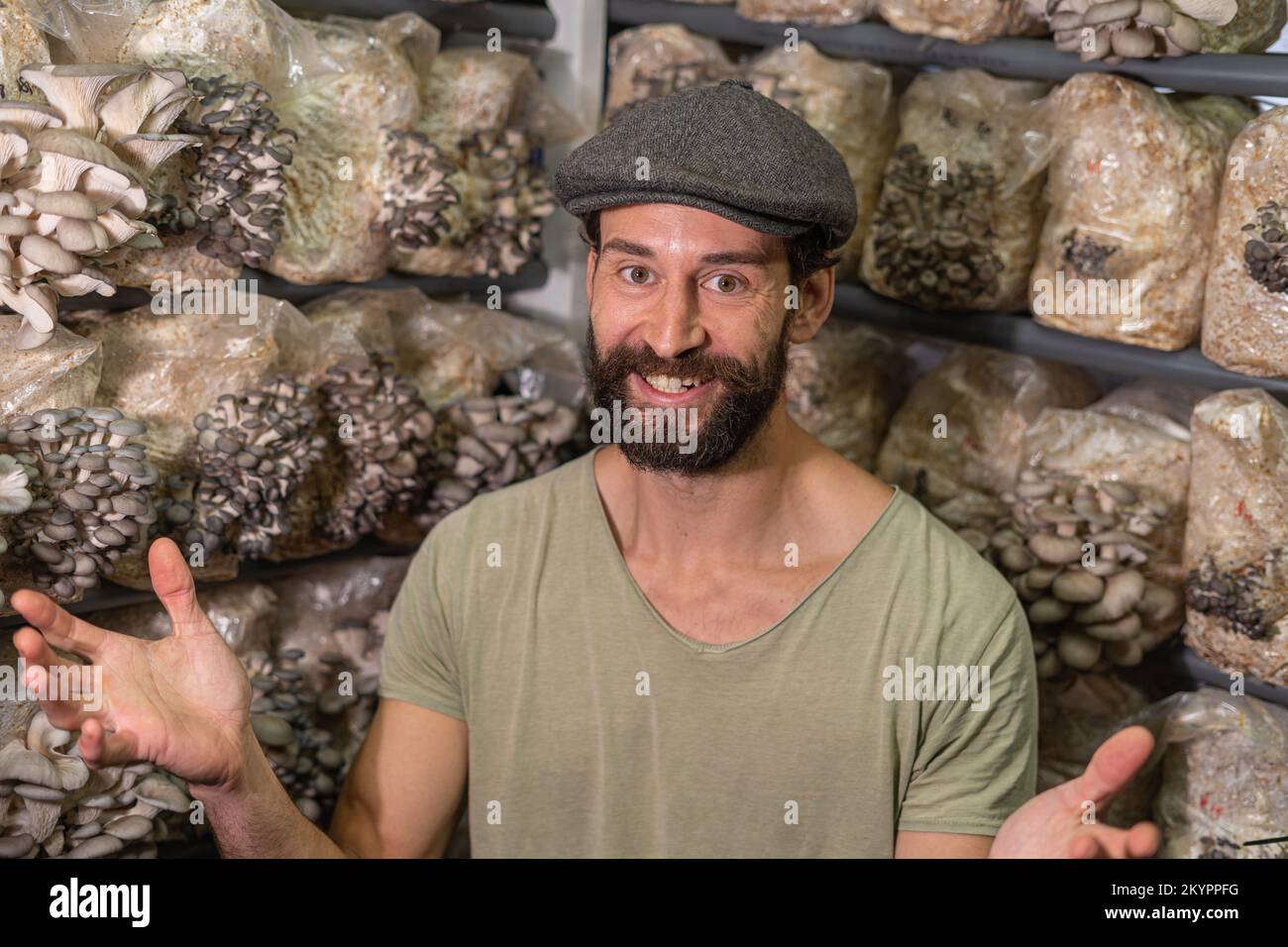 Giovane uomo felice - proprietario di serra di fungo domestica. Foto Stock