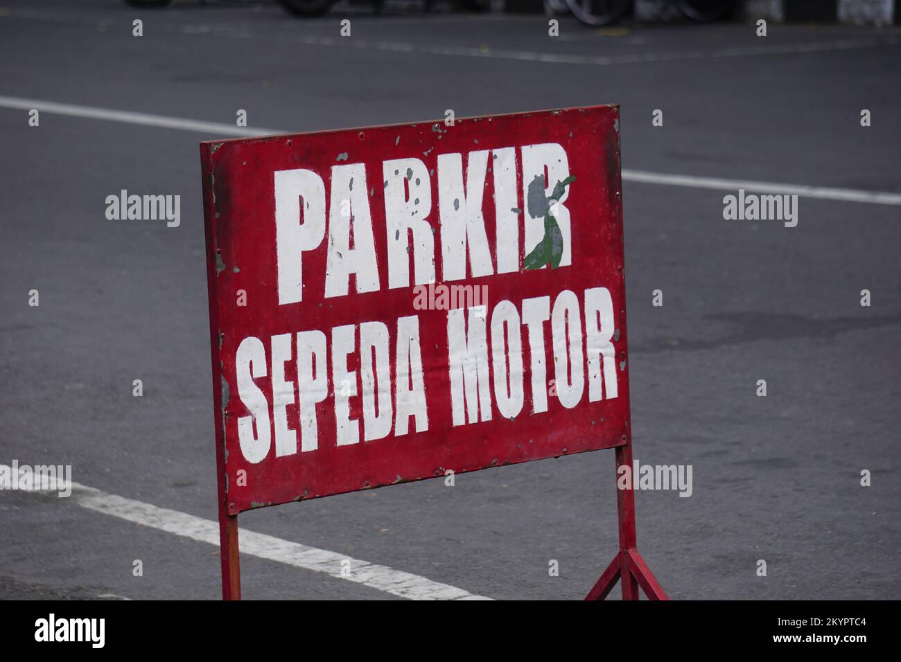 Cartello di parcheggio rosso sulla strada. Parkir sepeda motor significa posto per il parco moto Foto Stock