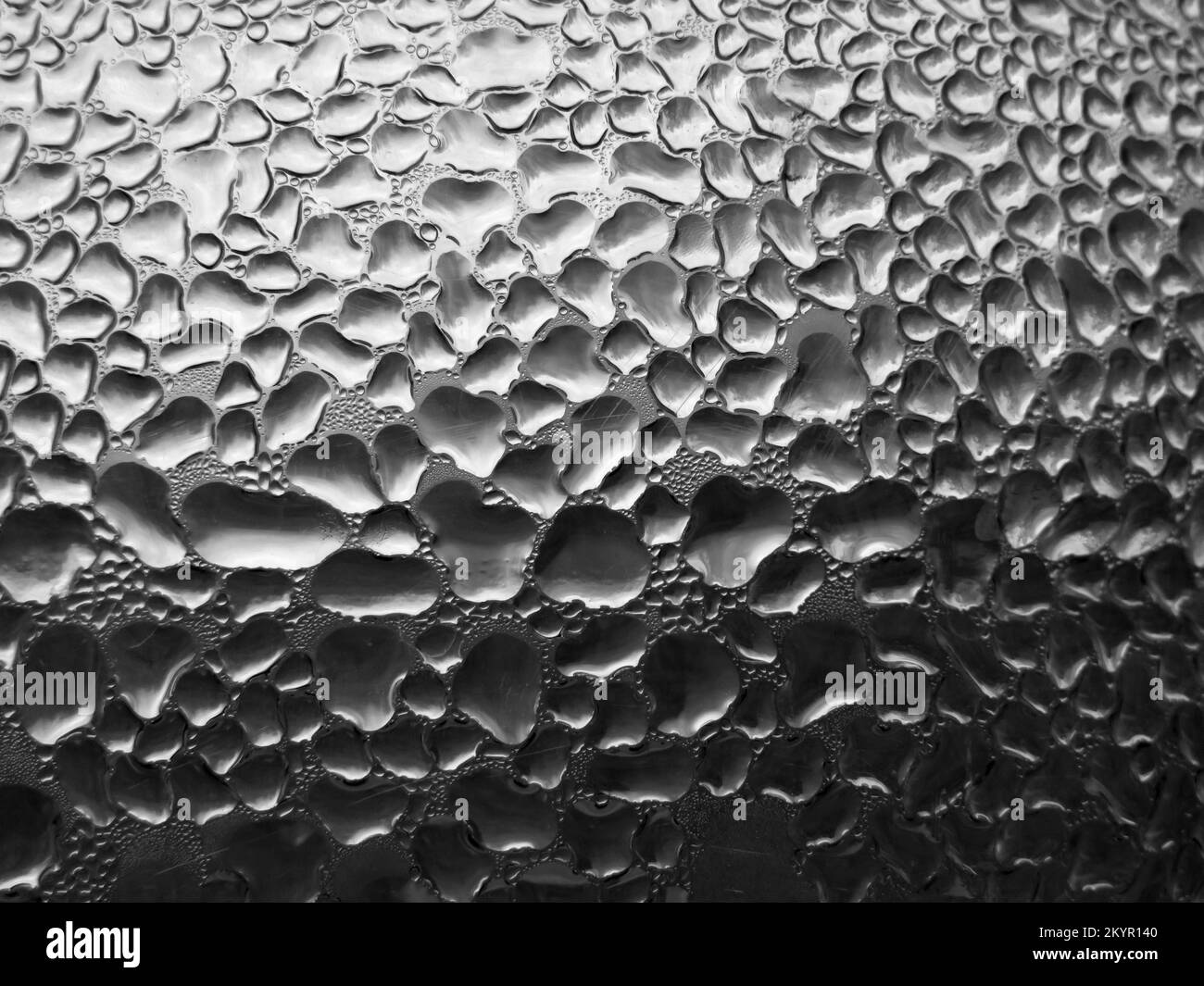 Vetro con gocce di pioggia su sfondo di tonalità scure. Struttura bagnata astratta con bolle sulla superficie del vetro della finestra. Gocce d'acqua pura realistica conde Foto Stock