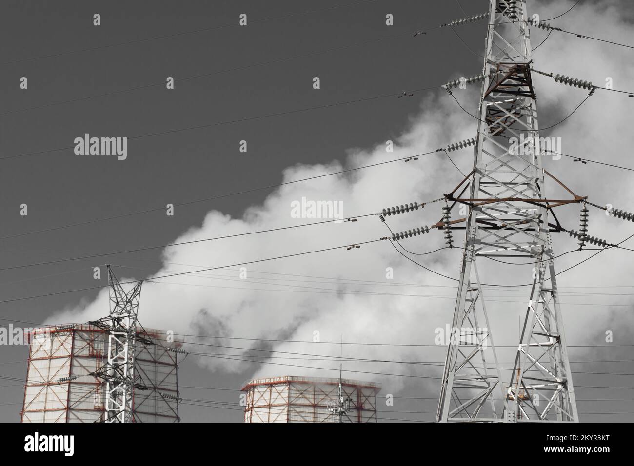Torre di raffreddamento del fumo inquinamento dell'ambiente del cielo grigio dell'aria circostante dell'atmosfera proveniente dall'impianto industriale e dai fasci ad alta tensione delle linee elettriche Foto Stock