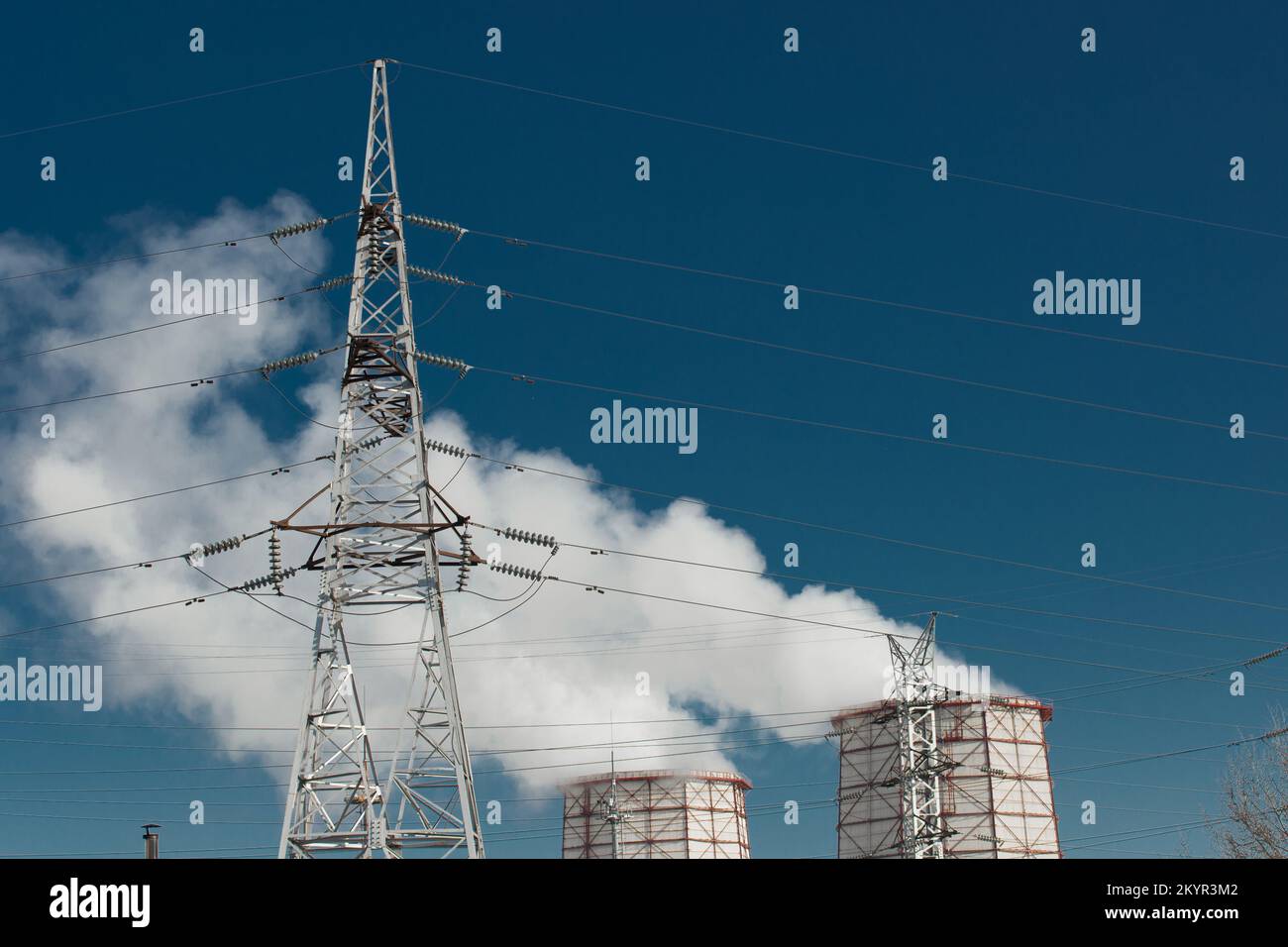 Torre di raffreddamento del fumo inquinamento dell'ambiente circostante dell'atmosfera proveniente dall'impianto industriale e dalla torre ad alta tensione delle linee elettriche. Foto Stock