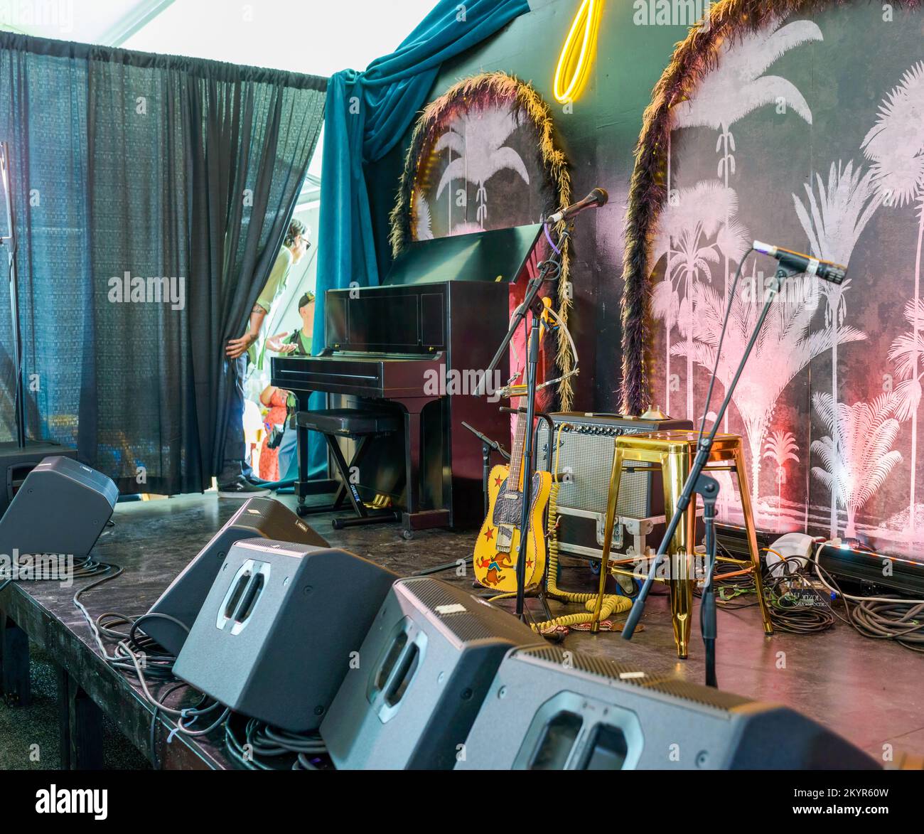 NEW ORLEANS, LA, USA - 29 APRILE 2022: AARP Stage setup come Eric Lindell tira indietro il sipario del palco preparandosi a fare il suo ingresso a Jazzfest Foto Stock
