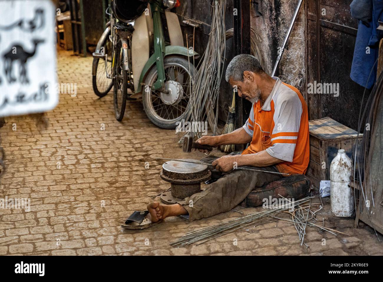 Metal worker che martellano il metallo in forma nella Medina di Marrakech, Marocco Foto Stock