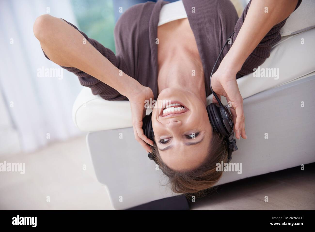 Godendo di una terapia musicale. Una giovane donna felice che ascolta la musica con le cuffie. Foto Stock