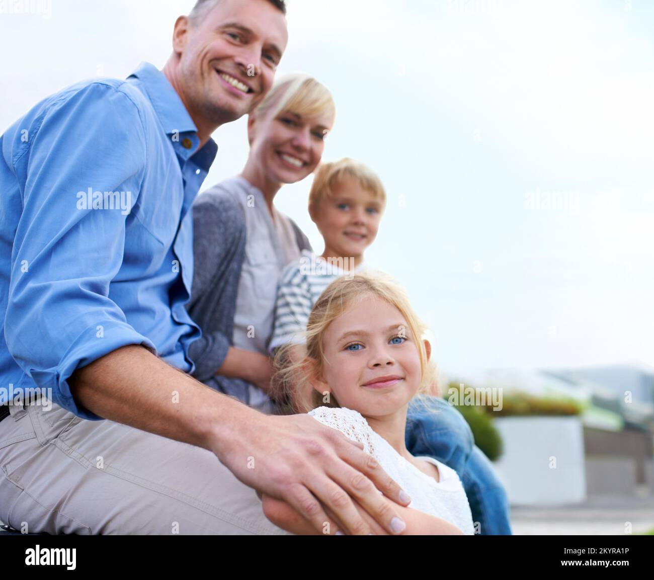 Mi sostengo con l'amore della famiglia. Una famiglia felice di due generazioni sorridente mentre all'aperto. Foto Stock