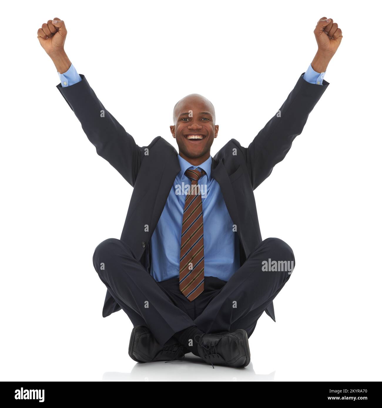Successo finalmente. Un felice uomo d’affari afro-americano seduto con le braccia sollevato in un’espreda di trionfo. Foto Stock