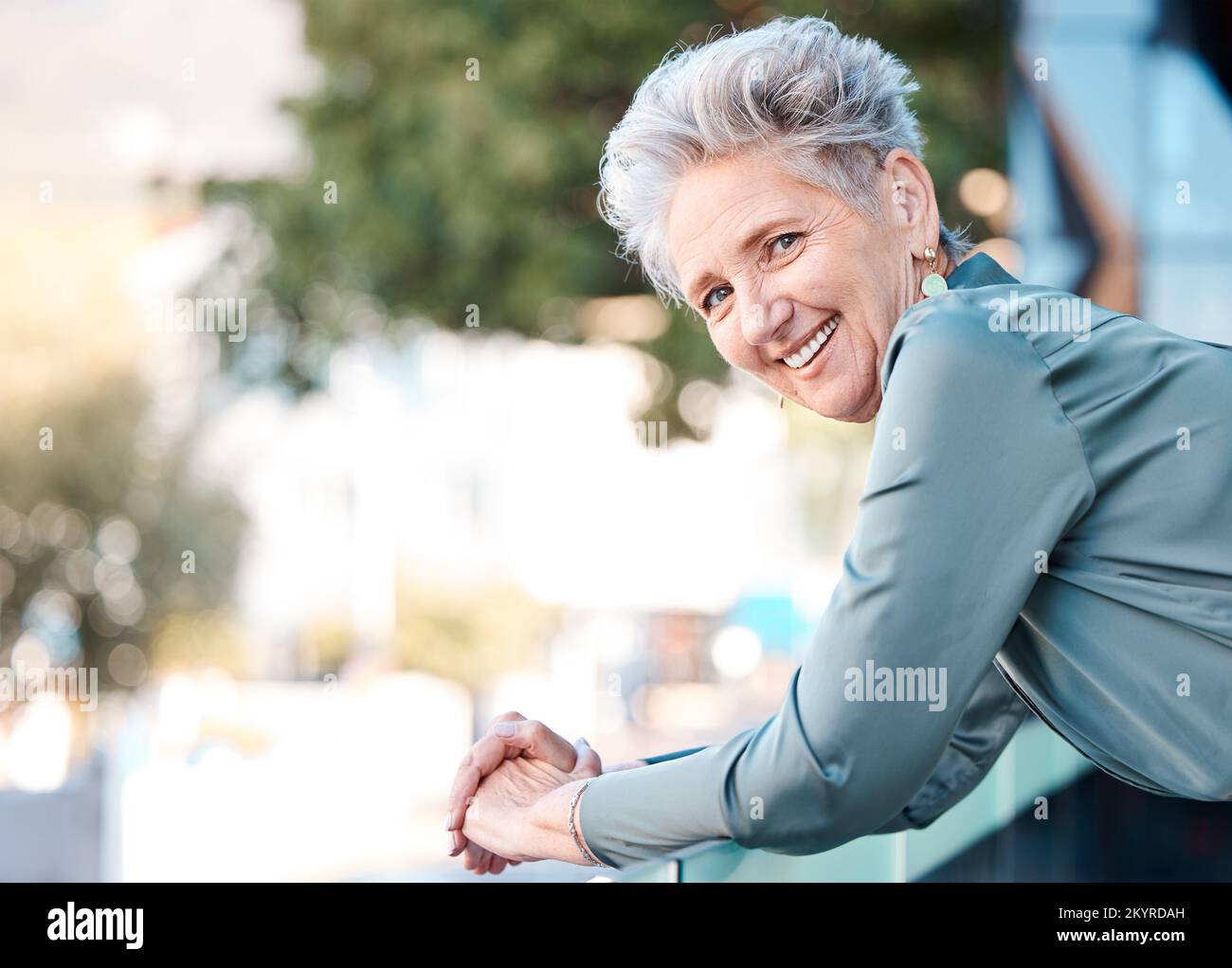 Ritratto, città e mockup con una donna manager in attività in piedi all'aperto sul balcone del suo ufficio. Faccia, felice e sorridi con una femmina anziana Foto Stock