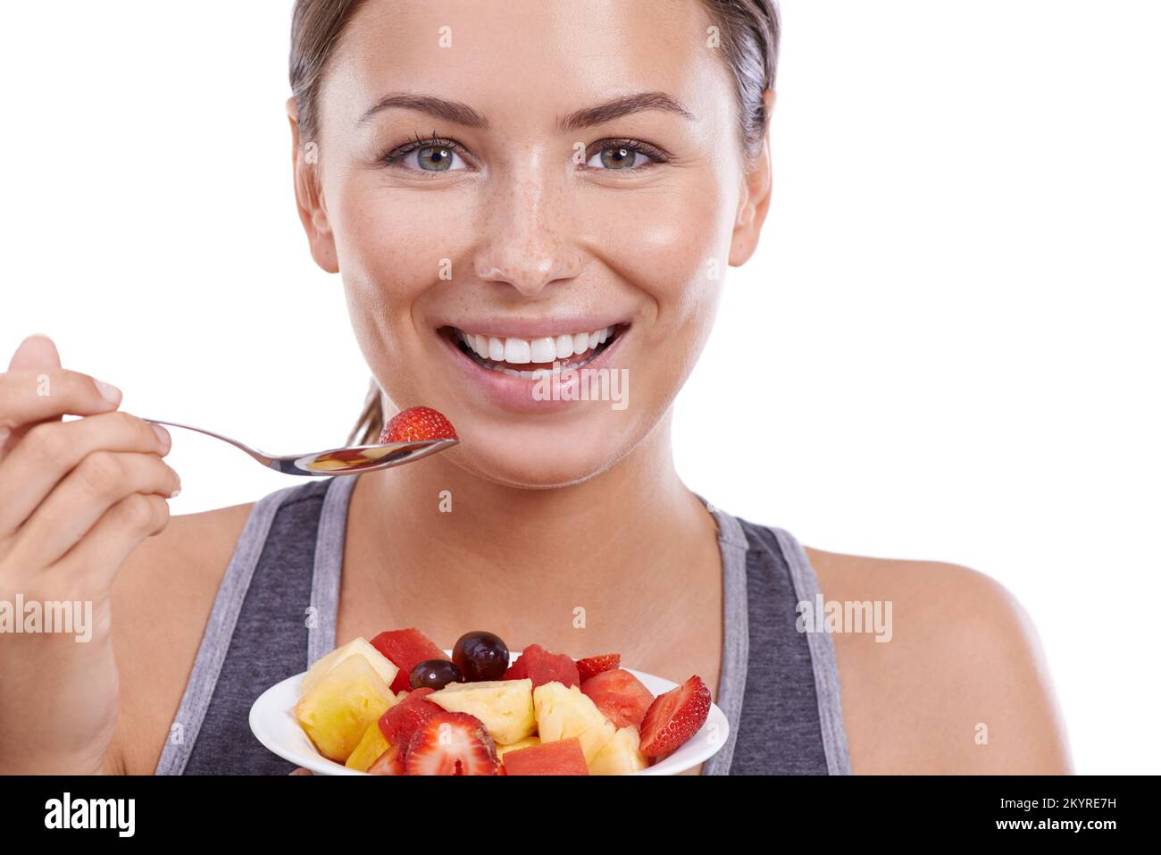 Ama vivere in modo sano. Ritratto di una giovane donna attraente che mangia una ciotola di Macedonia di frutta. Foto Stock