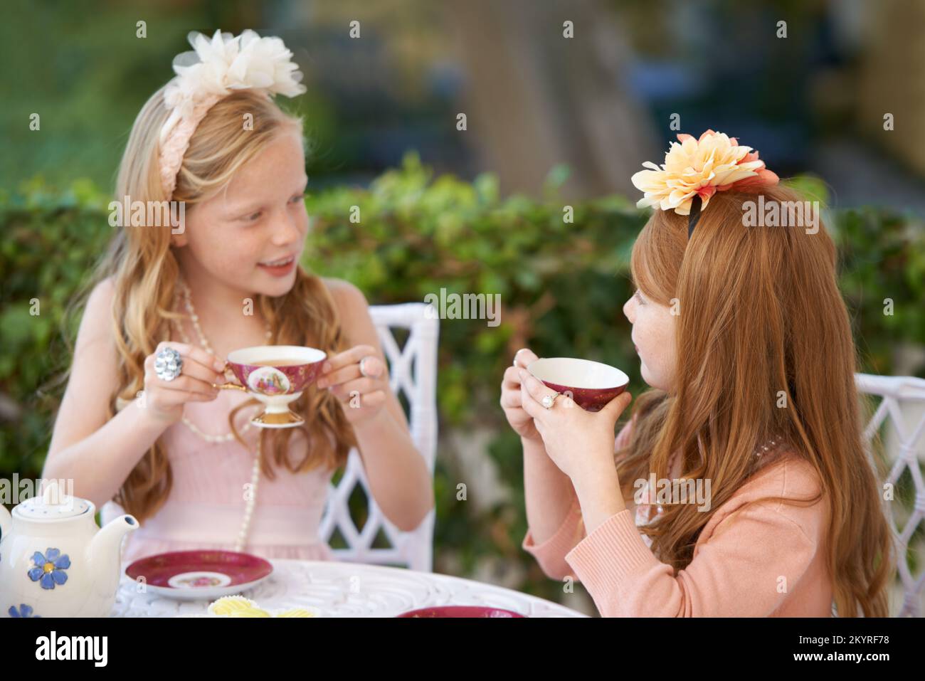 Una festa del tè fai-da-te. Due ragazze giovani che hanno un partito del tè nel cortile posteriore. Foto Stock